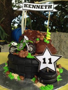 a motorcycle themed birthday cake with rocks and grass on the top, stars in the middle