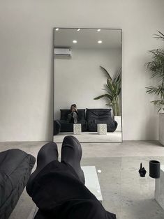 a person laying on the floor in front of a mirror with their feet propped up