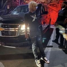 a man standing in front of a black truck