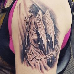 an angel tattoo on the back of a woman's shoulder with words love never ends