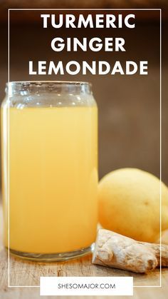 a glass jar filled with liquid next to lemons and ginger on top of a wooden table