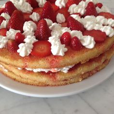 a stack of pancakes topped with strawberries and whipped cream