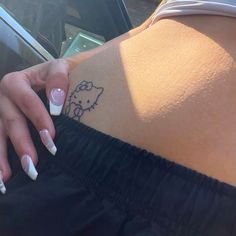 a woman's left arm with a hello kitty tattoo on it