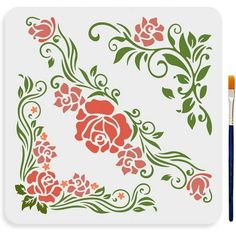 an artistically designed stencil with flowers and leaves on white paper next to a paintbrush