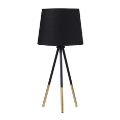 a black and gold floor lamp with a black shade on the top, standing upright