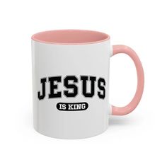 a pink and white coffee mug with the word jesus is king printed on it's side