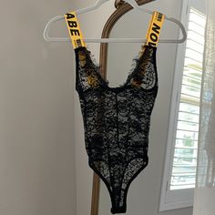 Lace Fabric | Delicate Detail At Neckline | Yellow Straps With Brand Name | Clips At The Bottom | *New Trendy Yellow Bodysuit For Party, Casual Yellow Bodysuit For Party, Sleeveless Lace Bodysuit, High Rise Bodysuit, Black Sheer Bodysuit, Pink Lace Bodysuit, Deep V Bodysuit, Bell Sleeve Bodysuit, Fashion Nova Bodysuit