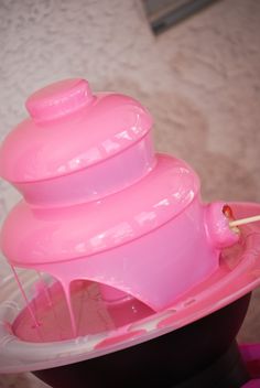 a pink cup filled with liquid sitting on top of a table