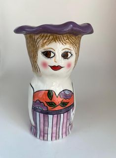 a ceramic figurine with a purple hat on it's head and eyes