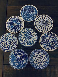 six blue and white plates sitting on top of a wooden table