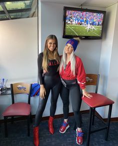 two women are posing in front of a tv