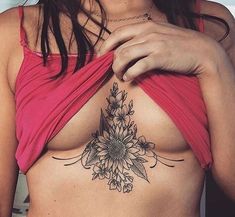 a woman's breast with a flower tattoo on her chest and the bottom part of her stomach