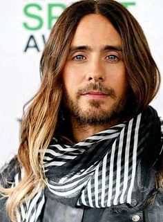 a man with long hair wearing a scarf