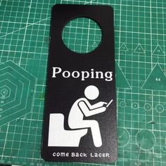 a door hanger that says pooping come back later on the floor next to a cutting board