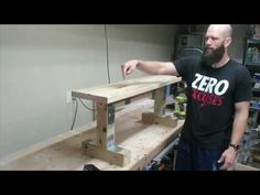 a man standing next to a wooden table