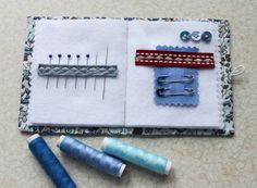 sewing supplies laid out on top of a piece of fabric with scissors and thread in the middle