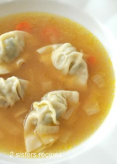 soup with dumplings and carrots in a white bowl