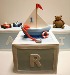 a cake with a boat, teddy bear and other toys on it's side