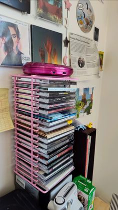 a stack of cd's sitting on top of a table next to a wall