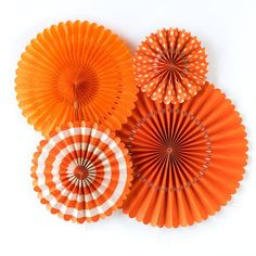 three orange paper fans sitting next to each other