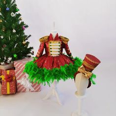 a dress made out of tulle and feathers next to a christmas tree with presents