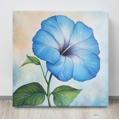 a blue flower on a canvas with green leaves