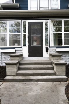 a house with steps leading up to the front door and windows on either side of it