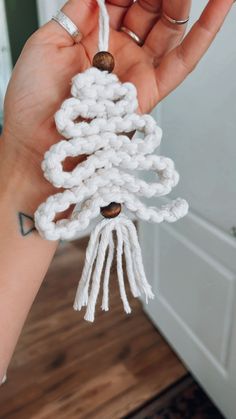 someone is holding up some white yarn