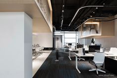 an empty office with desks and chairs in the center, along with other workspaces