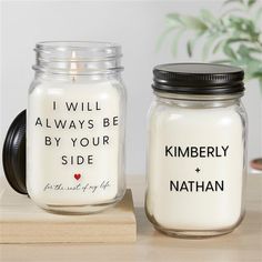 two mason jars with candles in them sitting on a table