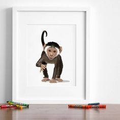 a painting of a monkey holding on to a piece of paper with crayons next to it