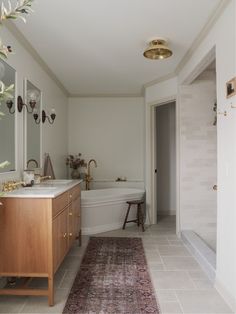 a bathroom with a rug on the floor and a bathtub in the corner next to it