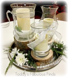 two glass vases filled with candles on top of a table