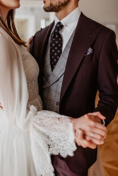 a man in a suit and tie standing next to a woman