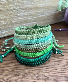 a stack of bracelets sitting on top of a wooden table