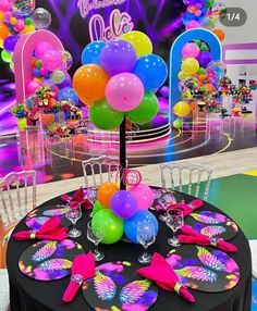 a table topped with lots of balloons and confetti on top of it's tables