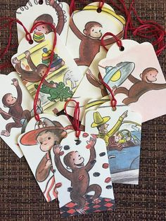 four tags with monkeys on them hanging from red string