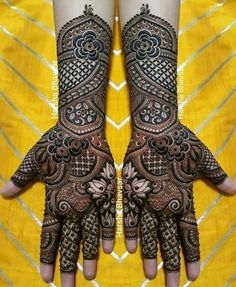 two hands that are decorated with henna and intricate designs on each hand, one is holding