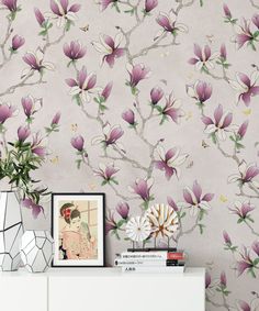 the wallpaper is decorated with pink flowers and green leaves, along with a white cabinet