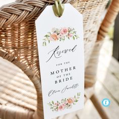 a white wedding gift tag hanging from a wicker chair with pink flowers on it