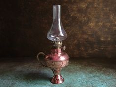 an antique brass oil lamp sitting on a table