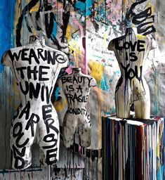 two mannequins are covered in graffiti and words