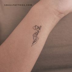 a woman's arm with a small flower tattoo on the left side of her arm