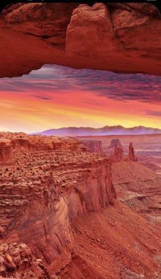 the sun is setting over canyons and mountains in this desert landscape with red rock formations