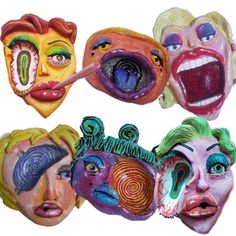 four masks with faces painted on them and one is sticking out his tongue to the side