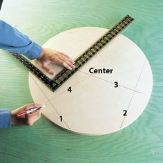 a person is measuring the height of a wooden object with a ruler on top of it