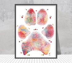 a colorful paw print on a white wall next to a gray and black framed frame