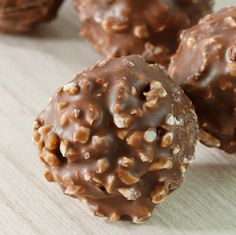 chocolate covered donuts sitting on top of a wooden table