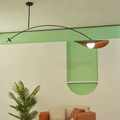 a living room filled with furniture and a green light hanging over the top of it