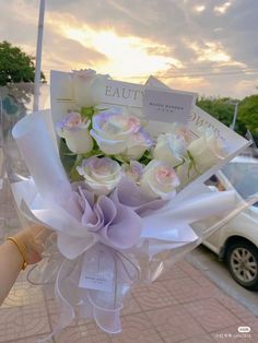 a bouquet of white roses in front of a car